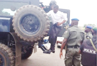 THE COMMISSIONER BEING LED AWAY IN A POLICE ARMORED CARRIER