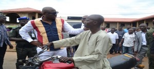 Ekiti State Governor, Dr. Ayodele Fayose (left) advising an Okada man to always wear his crash element and be careful while riding