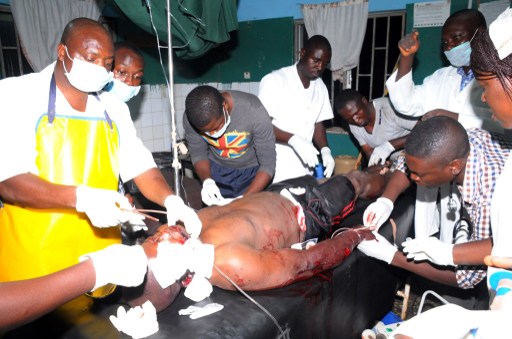 HEALTH WORKERS TAKE CARE OF AN INJURED VICTIM OF JOS BOMB BLAST ON DECEMBER 11, 2014 AT PLATEAU STATE SPECIALIST HOSPITAL, IN JOS. AFP PHOTO/STRINGER