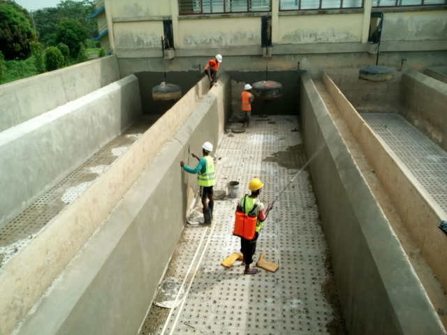 Men at work putting finishing touches at the Ezillo water treatment plant filter bed.