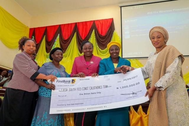 Wife of the Governor Rauf Aregbesola presenting N1m Cheque to the winners of the State of Osun Calisthenics Competitions which held in the 9 Federal Constituencies in the state.