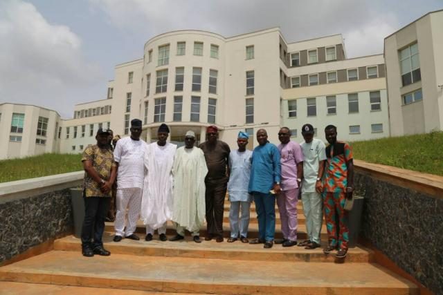 Group photograph with PDP Caretaker Committee Chairman, Senator Makarfi in front of the Library