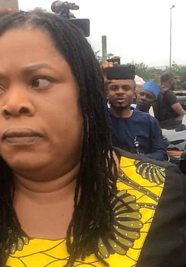 A woman in verbal engagement with masked security personnel at the NASS Complex, Abuja