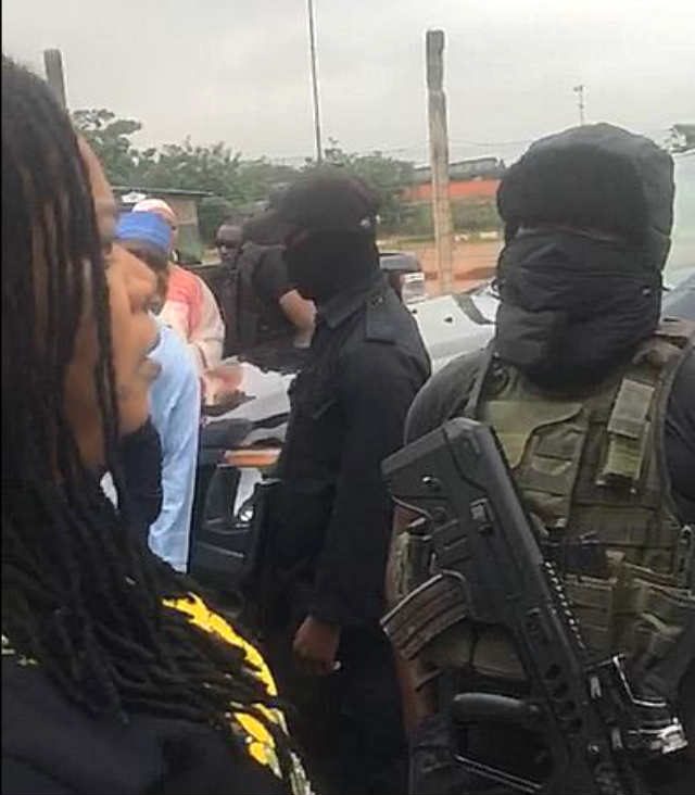 A woman in verbal engagement with masked security personnel at the NASS Complex, Abuja