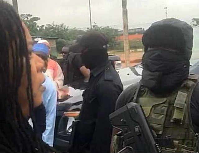 A woman in verbal engagement with masked security personnel at the NASS Complex Abuja