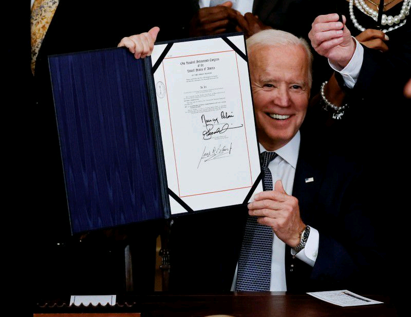 U.S. President Joe Biden is applauded as he holds the Juneteenth National Independence Day