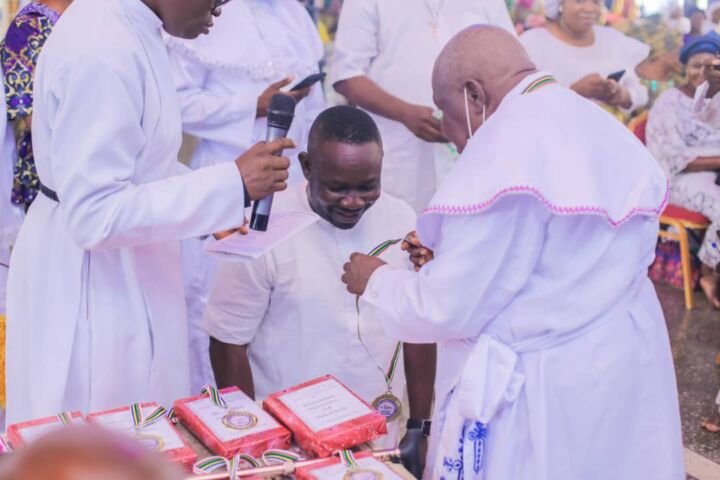 Superior Evangelist E.E Ewubajo decorating Asiwaju Oluwole with the medal of honor.