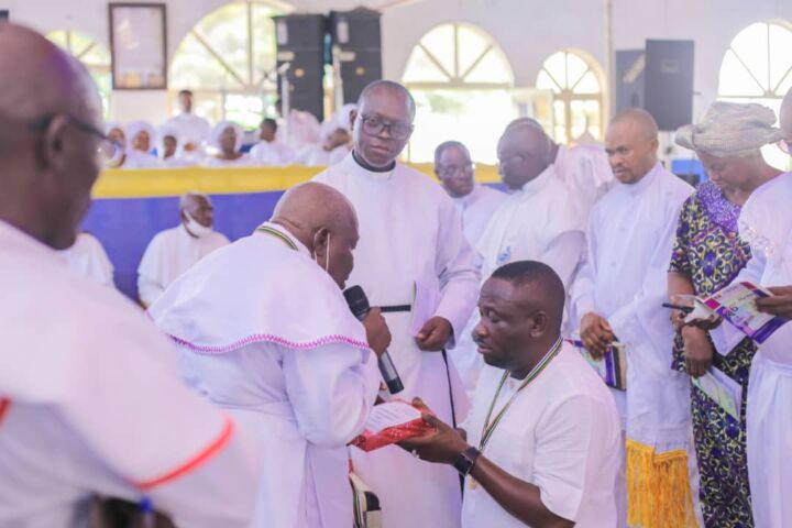 Superior Evangelist E.E Ewubajo presents The Holy Bible to Oluwole.